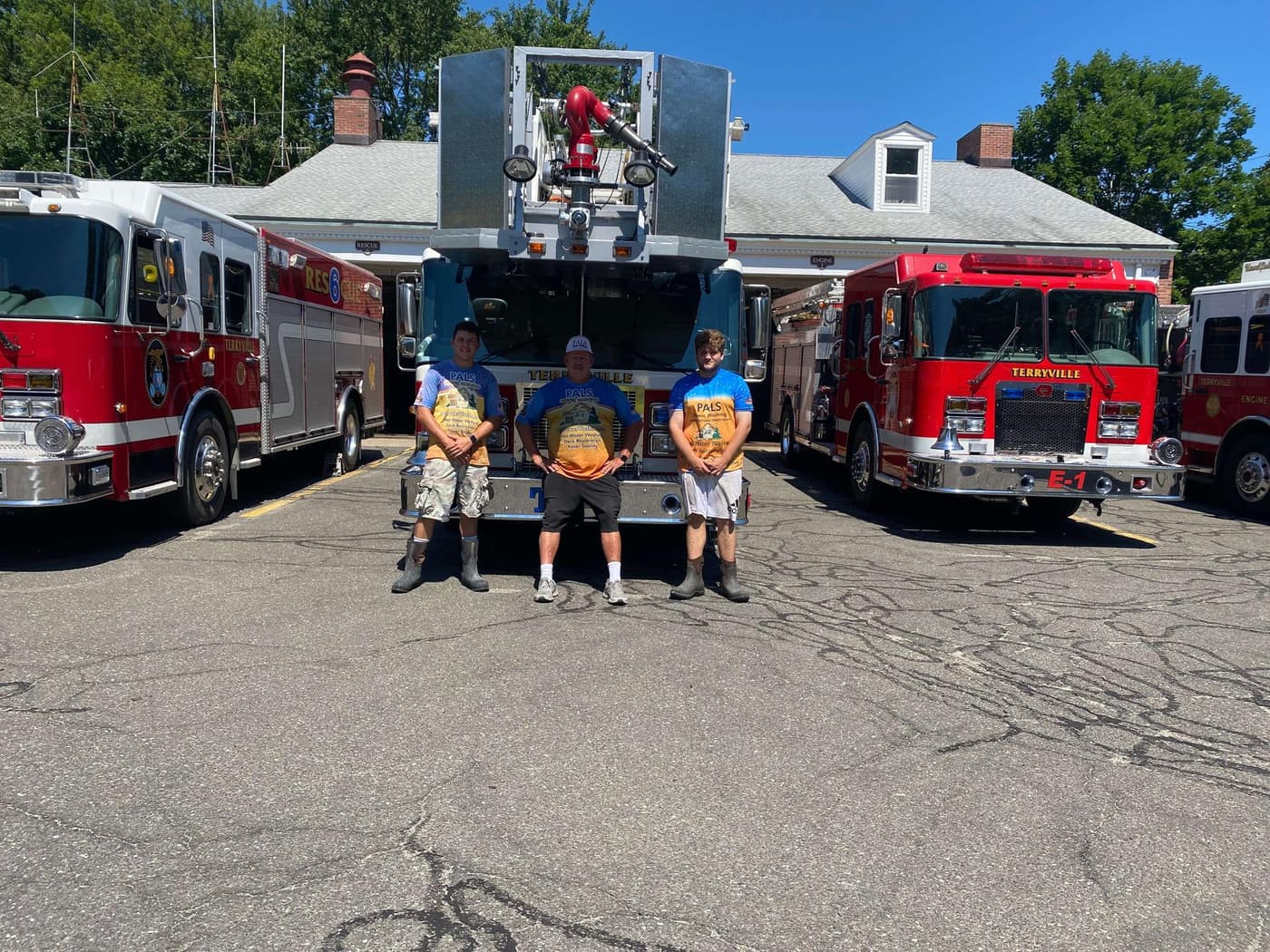 The Pals Power Washing team posing with Terryville fire trucks