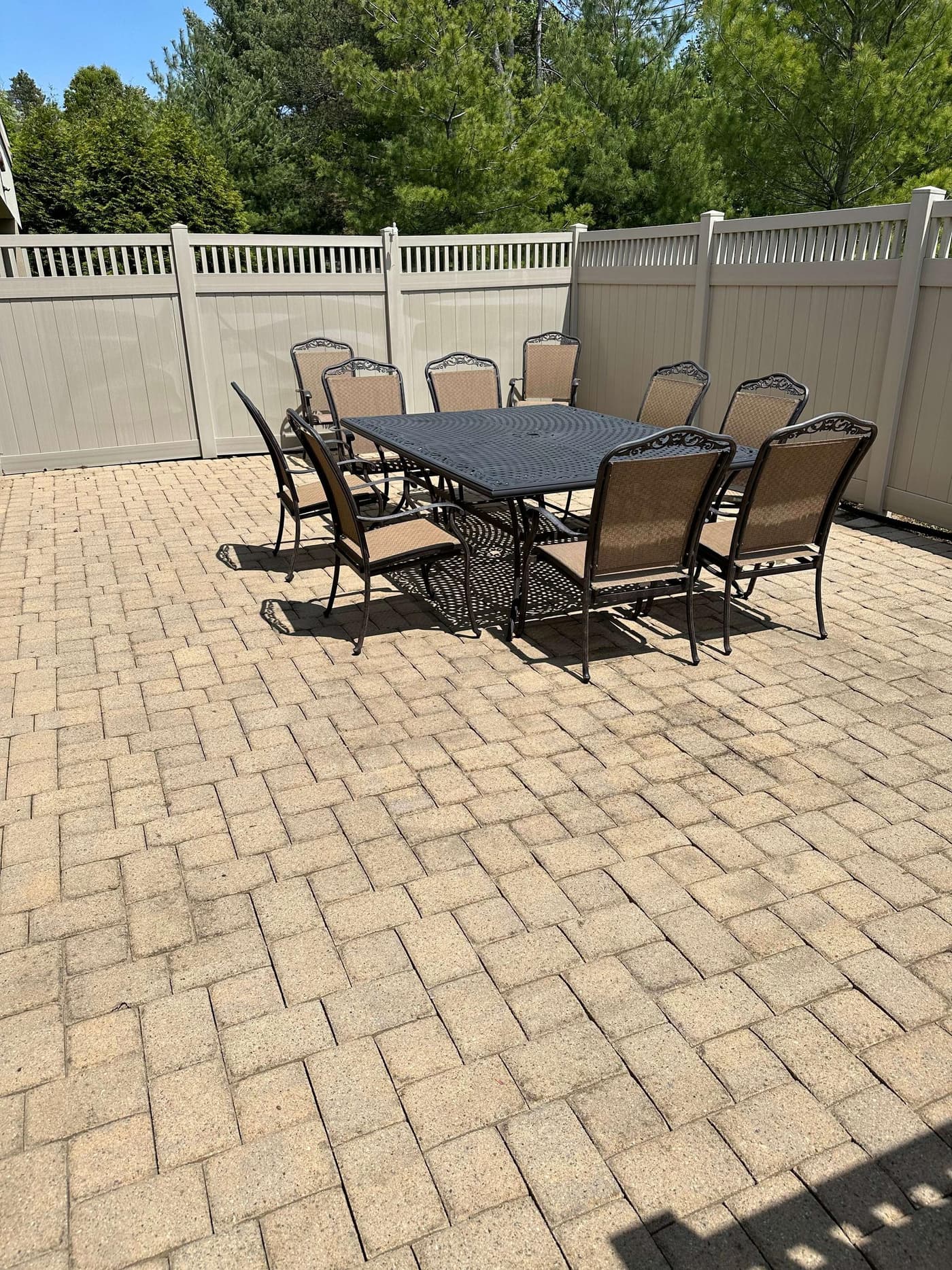 Cleaned brick paver patio with outdoor dining set and vinyl fence